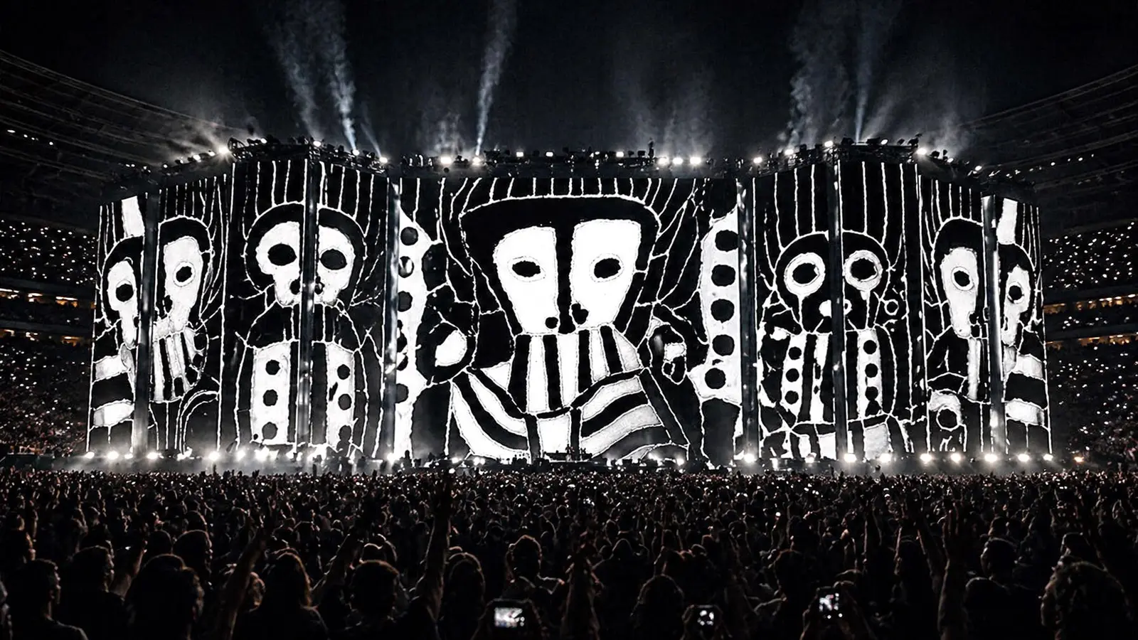 Simulation: a stadium stage clad in white-on-black drawn figures above a large crowd.